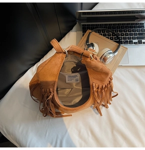 Vue intérieure du sac en daim marron montrant la doublure et les détails à franges