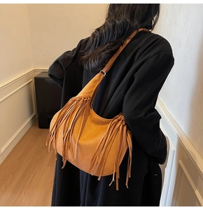 Gros plan détaillé d'un sac hobo en daim marron orné de longues franges élégantes