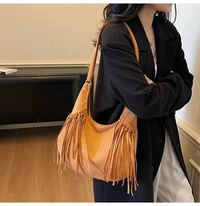 Détail du sac hobo en daim camel avec de longues franges élégantes et texture