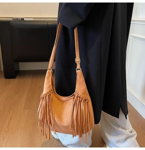 Détail du sac hobo en daim camel avec franges bohèmes et boucle en métal doré