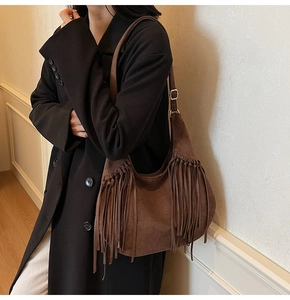 Vue détaillée d'un sac hobo en daim marron avec de longues franges et bandoulière