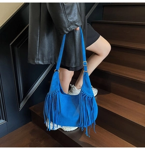 Détail d'un sac cabas en daim bleu roi avec de longues franges bohèmes et boucle