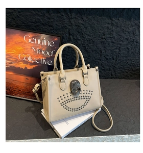Détail du sac crème avec relief tête de mort grise et clous décoratifs argentés