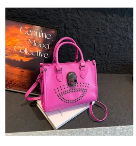 Détail du sac fourre-tout rose vif avec tête de mort argentée et cuir verni brillant