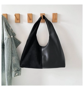 Detail of black shoulder bag with stylish contrast between suede and smooth leather textures