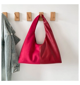 Detail of red shoulder bag with unique contrast of suede and smooth leather textures