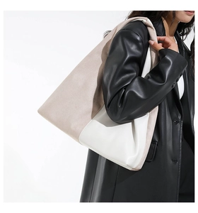 Detail of color-block tote bag with beige suede and white leather stitching texture