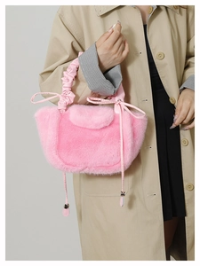 Detail of pink faux fur handbag showing soft plush texture and ribbon accent on shoulder bag