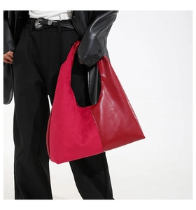 Detail of red hobo bag featuring contrasting matte suede and smooth leather patchwork