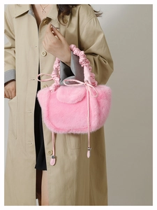 Detail of pink faux fur shoulder bag with ruched strap on a khaki trench coat