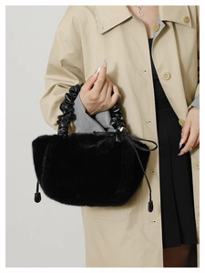 Detailed macro view of the black plush dumpling bag with a scrunched leather handle