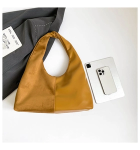 Macro view of ginger yellow shoulder bag featuring velvet and smooth leather patchwork