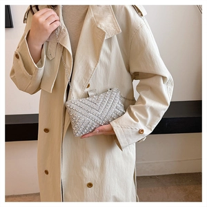 Detailed close-up of a silver rhinestone evening clutch with V-pattern and chain strap