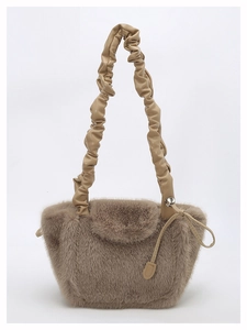 Detail of plush brown faux fur texture and PU pleated shoulder strap of the handbag
