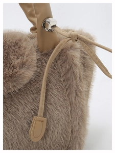 Detailed close-up of soft faux fur texture with leather handle and metal cord lock