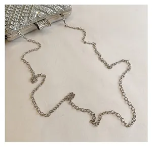 Detailed view of silver rhinestone evening clutch bag with thin metal chain strap