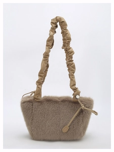 Close-up of fluffy faux fur texture and elegant ruched leather handle on beige tote