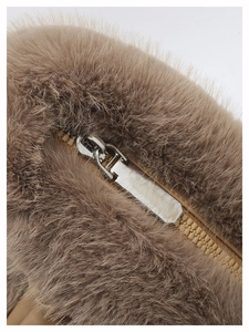Macro detail of high-quality khaki faux fur texture and metal zipper on plush shoulder bag