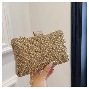 Macro view of glittering gold rhinestones in herringbone pattern on a luxury clutch bag