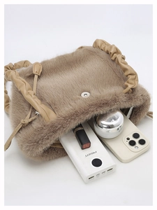 Close-up of brown faux fur handbag showing magnetic clasp and pleated leather handle