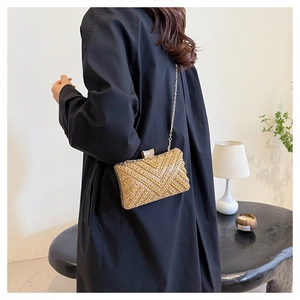 Detail showing gold rhinestone evening clutch with V-shaped geometric pattern and chain