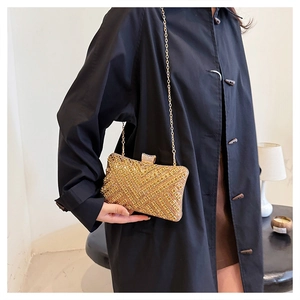 Detailed view of luxury gold rhinestone evening clutch with chain strap and crystal clasp