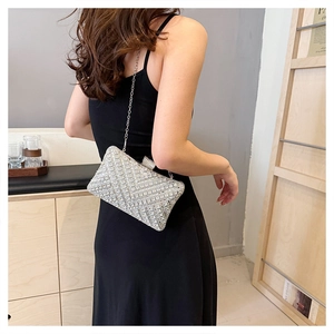 Detailed close-up of a luxury silver rhinestone clutch bag with elegant chain strap