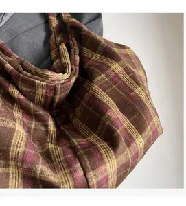 Gros plan d'un sac cabas à carreaux en tissu texturé doux marron café et jaune