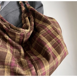 Détail du sac cabas à carreaux en laine avec anneau de réglage métallique sur la bandoulière