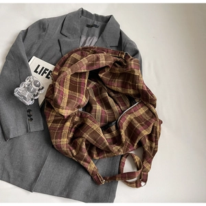 Détail du grand sac cabas à carreaux avec fermeture éclair sur une veste grise