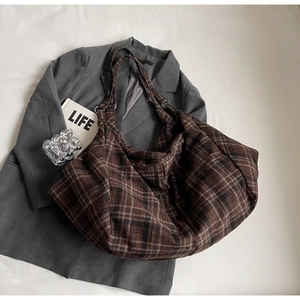 Vue détaillée du grand sac cabas à carreaux marron en tissu épais sur un blazer