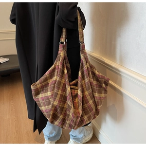 Détail du grand sac cabas à carreaux avec anneaux métalliques et texture en tissu doux