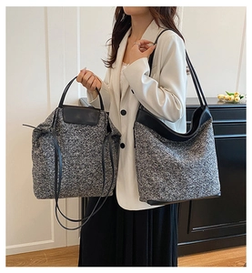 Close-up of grey tweed tote bags with premium leather straps and textured wool finish