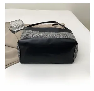 Detail view of the durable black leather base on a large wool tote shoulder bag