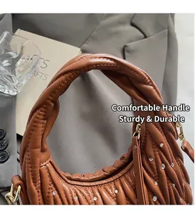 Detail of brown pleated leather handbag with sparkling rhinestones and woven handle