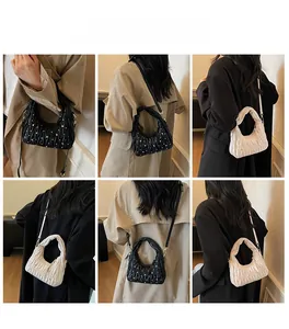 Detail view of ruched cloud bag with silver metal studs and adjustable shoulder strap