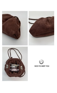 Detailansicht der braunen Wildleder-Cloud-Bag mit Metallverschluss und Schultergurt