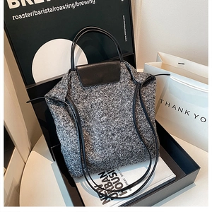 Detail of wool blend tote bag showing textured knit fabric and premium leather handle