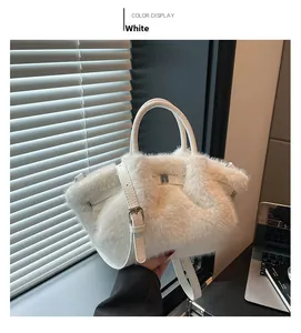 Detail of white faux fur bucket bag with smooth leather handle and metal hardware