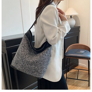 Close-up of grey wool blend tote bag with black leather straps on a stylish model