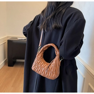 Detail of brown pleated leather hobo bag with sparkling rhinestones and moon shape