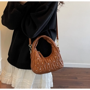 Detail of brown quilted faux leather bag with rhinestone accents and gold hardware