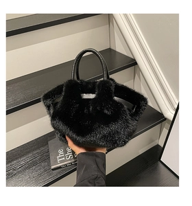 Detailed view of the soft black plush texture and leather handle on the women's winter bag
