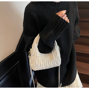 Detalle de mini bolso blanco plisado Matelassé con brillantes y herrajes dorados