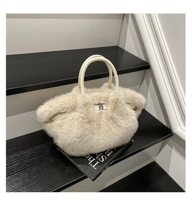 Close-up of off-white faux fur handbag with plush texture and silver metal buckle