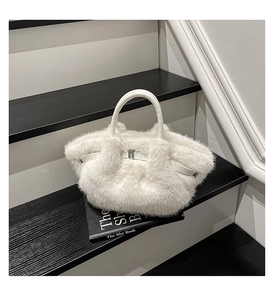 Detail of white faux fur handbag with silver metal buckle on a minimalist staircase