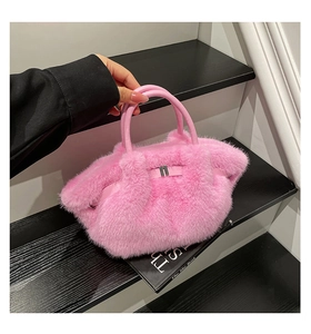 Close-up of plush pink faux fur handbag featuring soft texture and leather handles