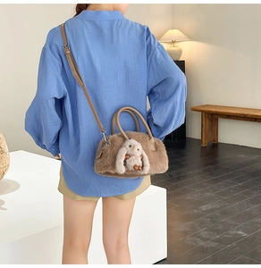 Borsa Boston in peluche marrone con decorazione a coniglio 3D indossata da una modella