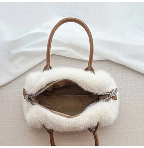 Dettaglio borsa in ecopelliccia bianca con manici in finta pelle marrone e cerniera argento