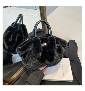 Detail of black faux fur handbag with leather handle and silver metal buckle closure